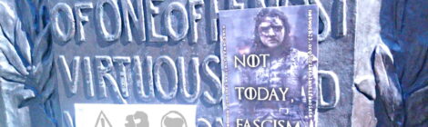 a plaque commemorating Colston with two antifascist sticers on it including 'not today, fascism' with a picture of Arya Stark