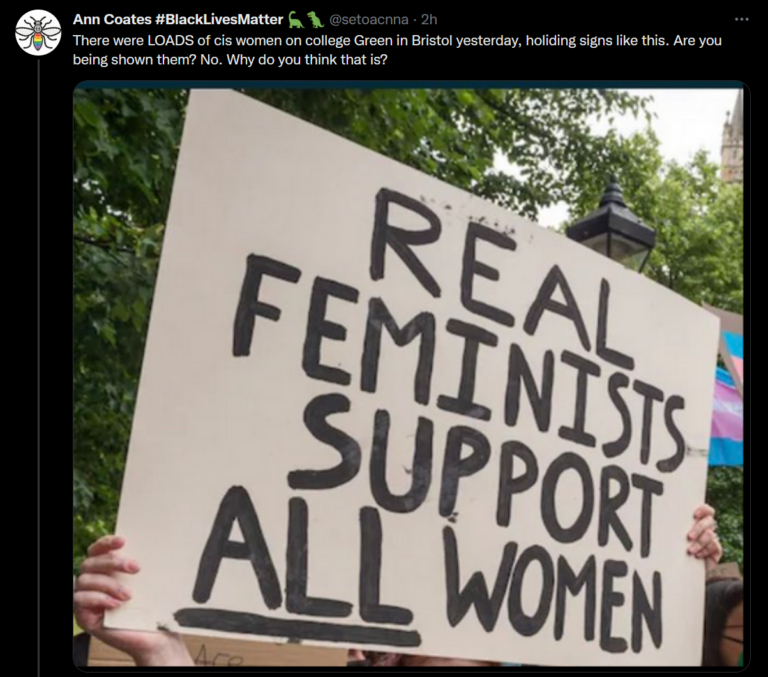 A tweet from @setoacnna "There were LOADS of cis women on college Green in Bristol yeseterday, holding signs like this. Are you being shown them? No. Why do you think that is?" the tweet shows an image of a placard saying 'real feminists support all women' being held aloft, with trees and trans flags in teh background. 