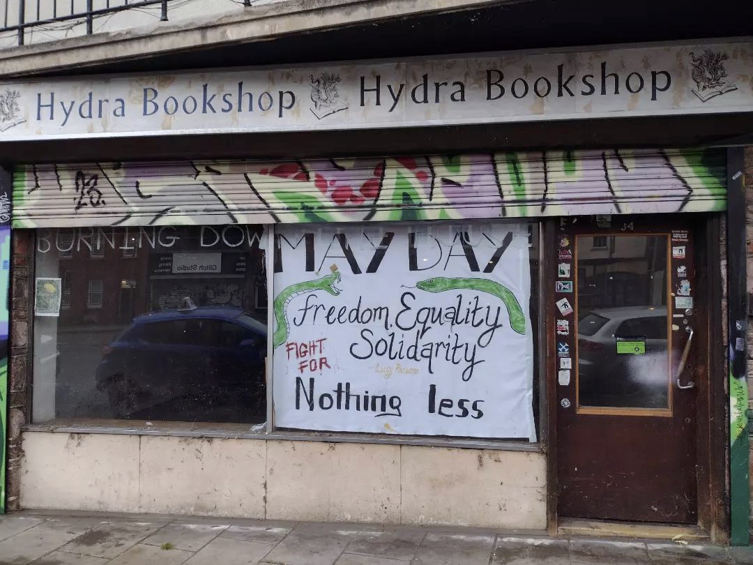 Hydra bookshop, with its shutters up, and a banner declaring freedom, quality, soldiarity. 